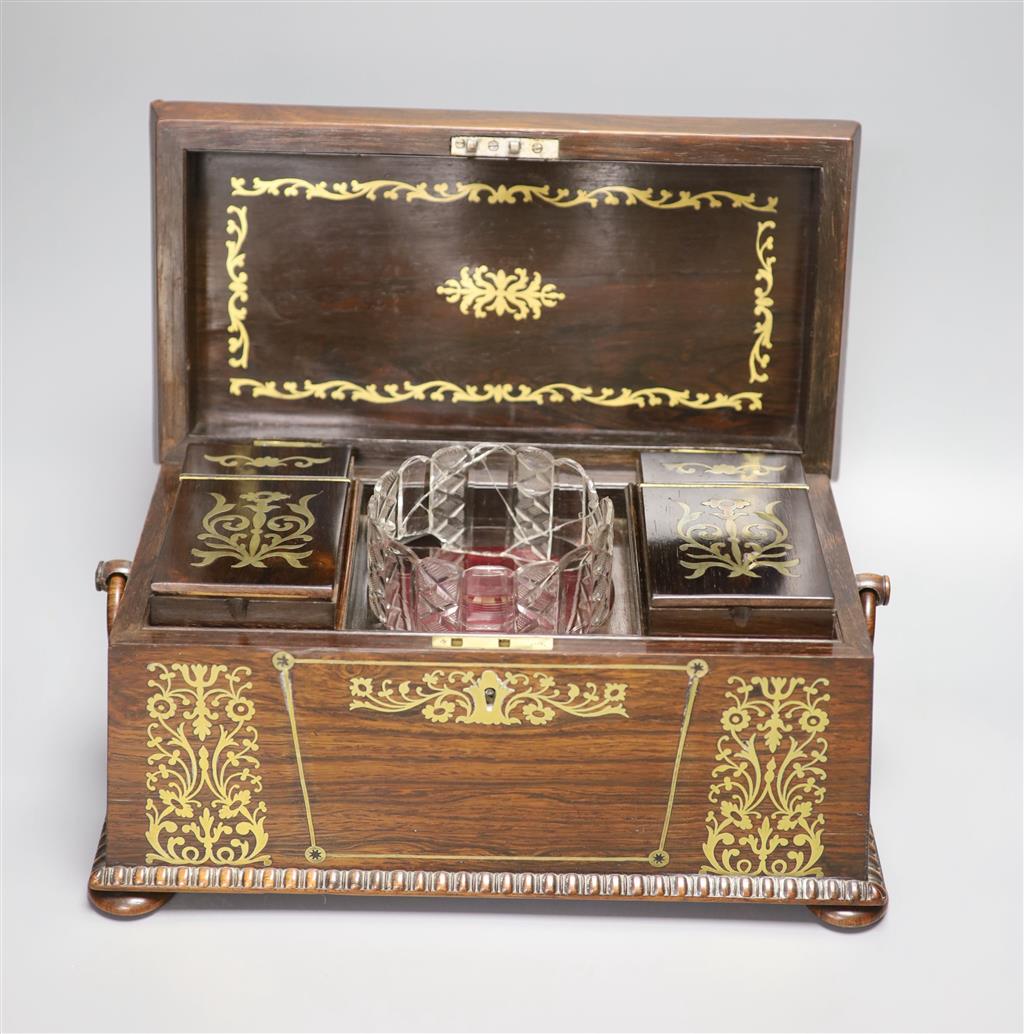 A Regency rosewood and cut brass inlaid sarcophagus shaped tea caddy, (mixing bowl restored), length 33cm